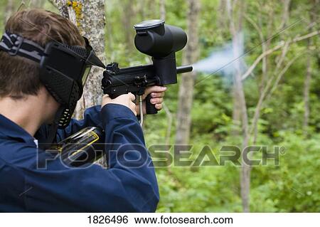 Man shooting paintball gun View Large Photo Image Stock Photograph - Man shooting paintball gun. Fotosearch