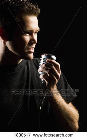 Stock Photo - Man singing in a microphone. Fotosearch