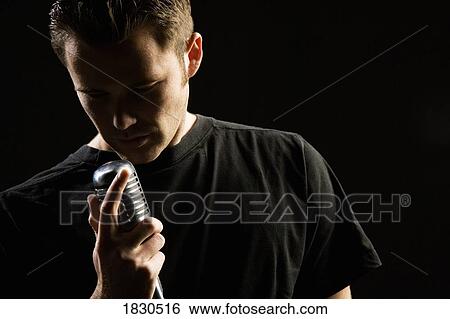 Stock Photograph - Man singing in a microphone. Fotosearch
