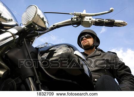 Man sitting on motorbike View Large Photo Image Stock Photo - Man sitting on motorbike. Fotosearch