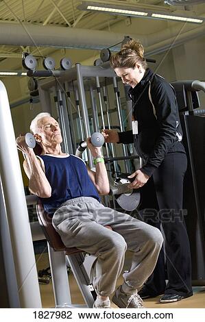 Stock Image - Man working out with trainer. Fotosearch