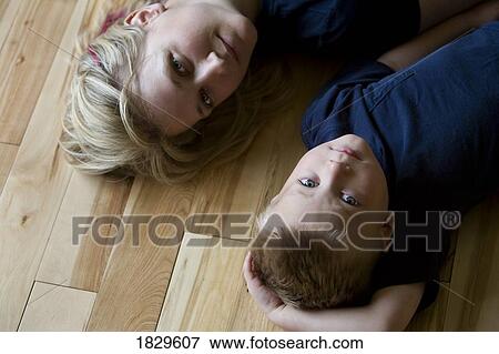 Stock Photo - Mother and son laying on the floor. Fotosearch