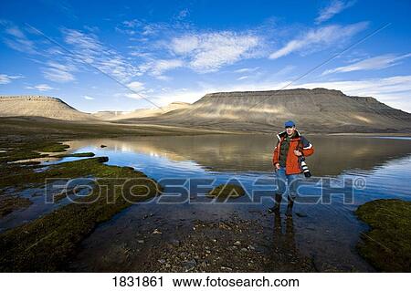Person standing at the edge of a lake, Nunavut, Canada View Large Photo Image Stock Image - Person standing at the edge of a lake, Nunavut, Canada. Fotosearch