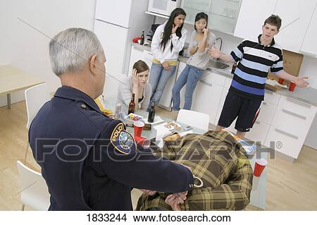 Picture - Police officer breaking up an under-age party. Fotosearch