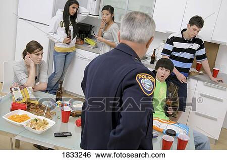 Stock Photograph - Police officer breaking up an under-age party. Fotosearch