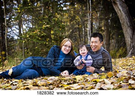 Portrait of family sitting in leaves View Large Photo Image Stock Image - Portrait of family sitting in leaves. Fotosearch