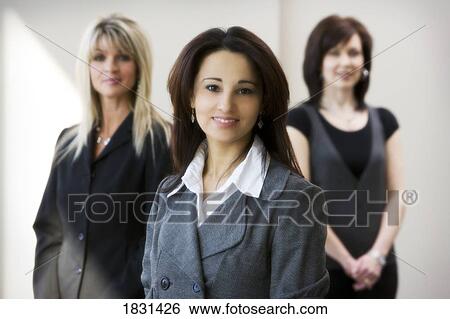 Stock Photograph - Portrait of woman with two others in background. Fotosearch