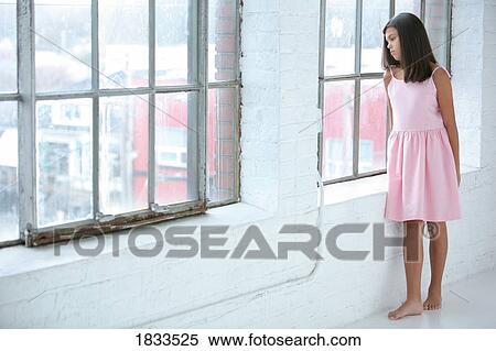 Preteen girl looking out of a window View Large Photo Image Stock Photography - Preteen girl looking out of a window. Fotosearch