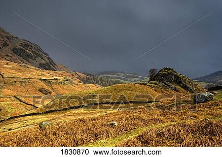Stock Image - Rain clouds over hilly landscape, Cumbria, England. Fotosearch