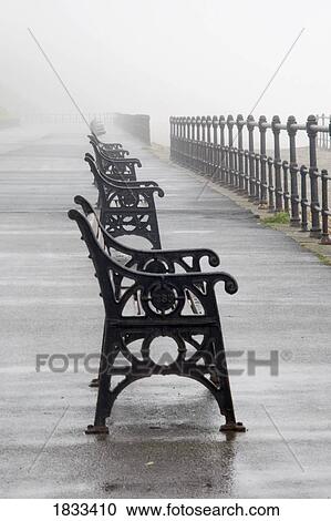 Stock Image - Redcar, North Yorkshire, England; Row of benches overlooking the beach and sea. Fotosearch