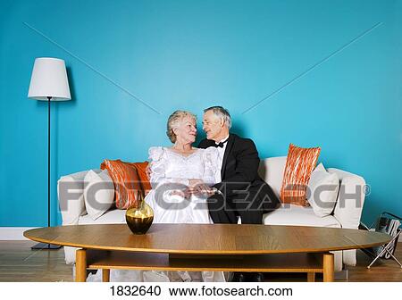 Stock Image - Senior bride and groom in living room. Fotosearch