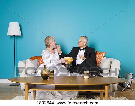 Picture - Senior couple relaxing on the couch. Fotosearch