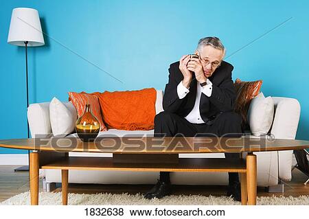 Stock Photo - Senior Man Sitting On The Couch Alone. Fotosearch