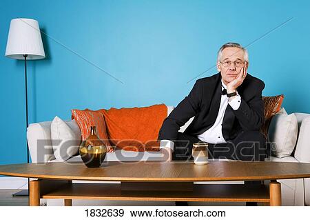 Stock Photo - Senior Man Sitting On The Couch Alone. Fotosearch