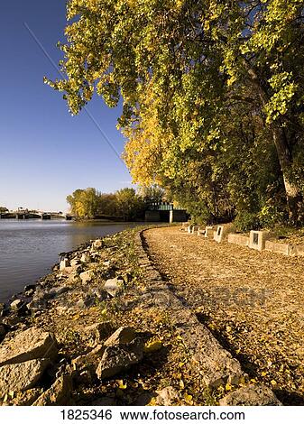 Stock Photograph - Shore along river at the Forks, Winnipeg, Manitoba, Canada. Fotosearch