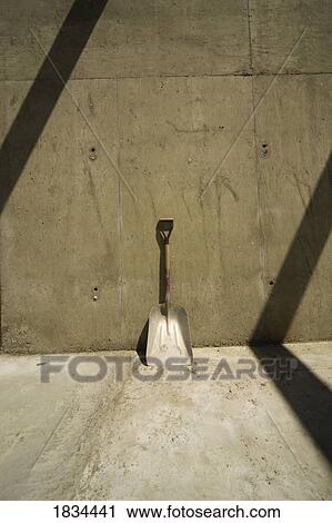 Shovel resting against a wall at a construction site View Large Photo Image Stock Image - Shovel resting against a wall at a construction site. Fotosearch