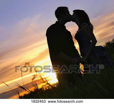 Stock Image - Silhouette Of A Couple Kissing. Fotosearch