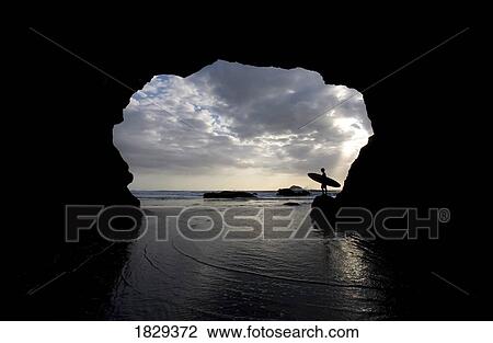Silhouette of surfer on beach through cave, Muriwai Beach, North Island, New Zealand View Large Photo Image Stock Image - Silhouette of surfer on beach through cave, Muriwai Beach, North Island, New Zealand. Fotosearch