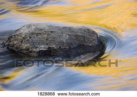 Stone in moving water View Large Photo Image Stock Photo - Stone in moving water. Fotosearch