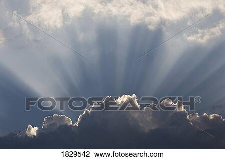 Stock Image - Sunlight shining up out of clouds. Fotosearch