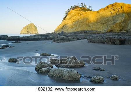 Stock Image - Sunrise Haystack Rock and Cape Kiwanda, Pacific City, Oregon, USA. Fotosearch