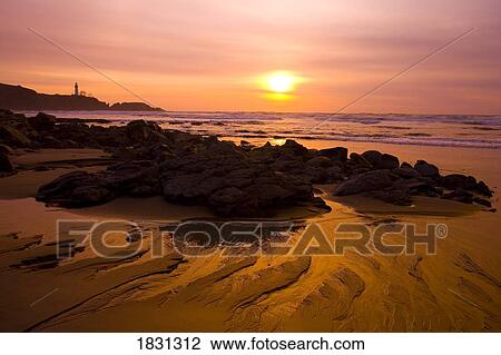 Stock Image - Sunset along beach and Yaquina Head Light, Oregon, USA. Fotosearch