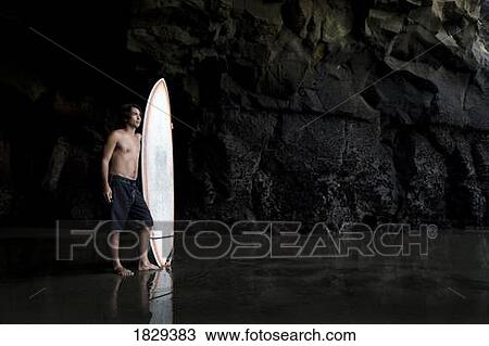 Surfer inside a cave at Muriwai, New Zealand View Large Photo Image Stock Image - Surfer inside a cave at Muriwai, New Zealand. Fotosearch