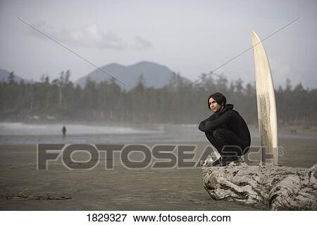 Stock Photo - Surfer on beach, Cox Bay near Tofino, British Columbia, Canada. Fotosearch