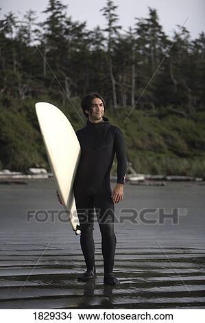 Surfer standing on beach, Cox Bay near Tofino, British Columbia, Canada View Large Photo Image Picture - Surfer standing on beach, Cox Bay near Tofino, British Columbia, Canada. Fotosearch