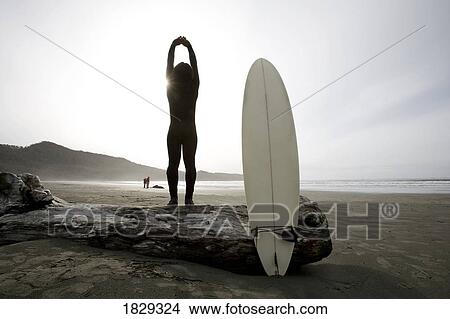 Surfer stretching on beach View Large Photo Image Picture - Surfer stretching on beach. Fotosearch