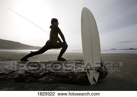 Surfer stretching on beach View Large Photo Image Stock Image - Surfer stretching on beach. Fotosearch