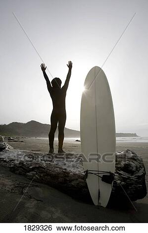 Stock Photograph - Surfer stretching on beach. Fotosearch