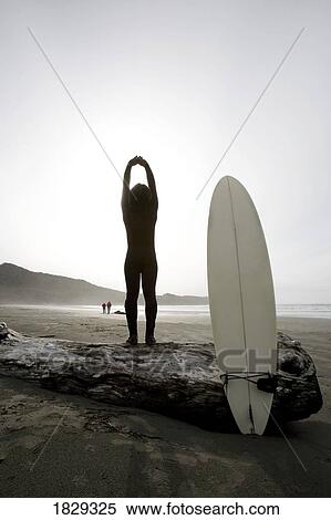 Stock Photography - Surfer stretching on beach. Fotosearch