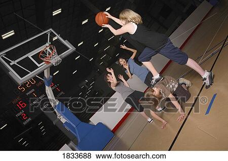 Stock Photo - Teenagers playing basketball. Fotosearch