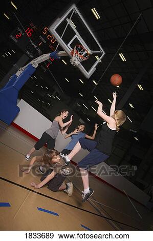 Stock Photo - Teenagers playing basketball. Fotosearch