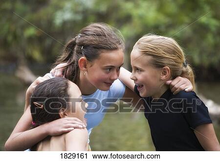 Stock Image - Three girls talking. Fotosearch