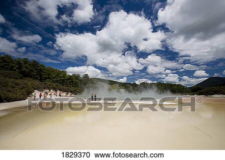 Stock Image - Tourists at geothermal site, Wai-O-Tapu Thermal Wonderland on North Island of New Zealand. Fotosearch