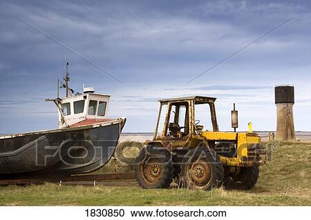 Tractor pulling away old fishing boat View Large Photo Image Stock Image - Tractor pulling away old fishing boat. Fotosearch