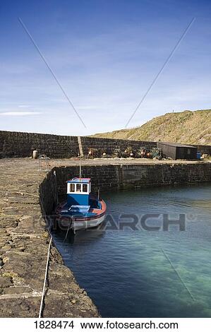Picture - Tugboat moored to stone dock, Scotland. Fotosearch