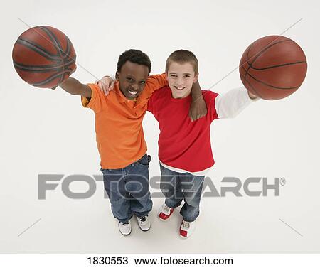 Two boys holding basketballs View Large Photo Image Stock Image - Two boys holding basketballs. Fotosearch