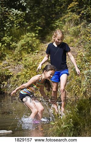 Stock Photo - Two girls playing in water. Fotosearch
