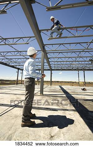 Stock Image - Two men on a job site. Fotosearch