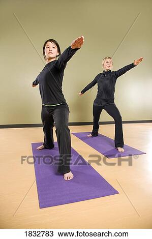 Stock Image - Two women doing stretches. Fotosearch