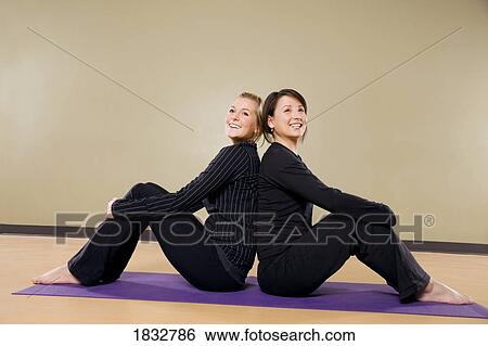 Stock Photograph - Two women sitting back to back. Fotosearch