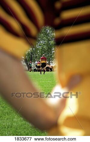 View of rugby player through the arms of another View Large Photo Image Stock Photo - View of rugby player through the arms of another. Fotosearch