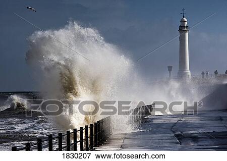 Stock Photo - Waves crashing by lighthouse at Sunderland, Tyne and Wear, England. Fotosearch
