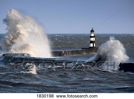 Stock Photo - Waves crashing by lighthouse, Seaham, Teesside, England. Fotosearch