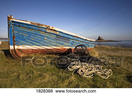 Stock Photo - Weathered fishing boat on shore, Holy Island, Bewick, England. Fotosearch