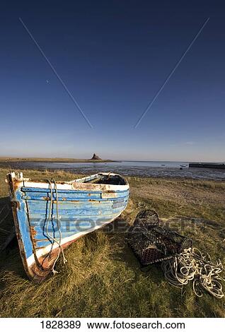 Weathered fishing boat on shore, Holy Island, Bewick, England View Large Photo Image Stock Photo - Weathered fishing boat on shore, Holy Island, Bewick, England. Fotosearch