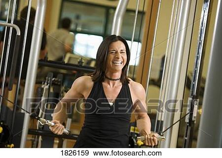 Stock Photo - Woman exercising at the gym. Fotosearch